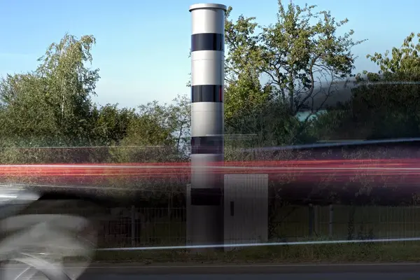 Auto fährt an Blitzer vorbei